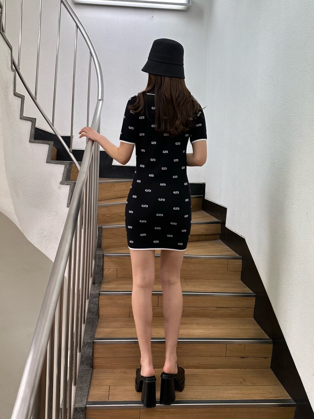 ブラック系のワンピース、ブラック系のサンダル、ブラック系のハットを着用したレディースの春コーディネートの3枚目の写真