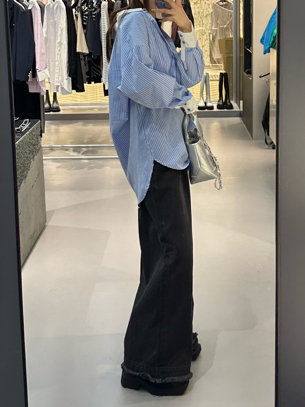 ブラック系のデニムパンツ、ホワイト系のキャミソール、ブルー系のシャツ/ブラウスを着用したレディースの冬コーディネートの2枚目の写真