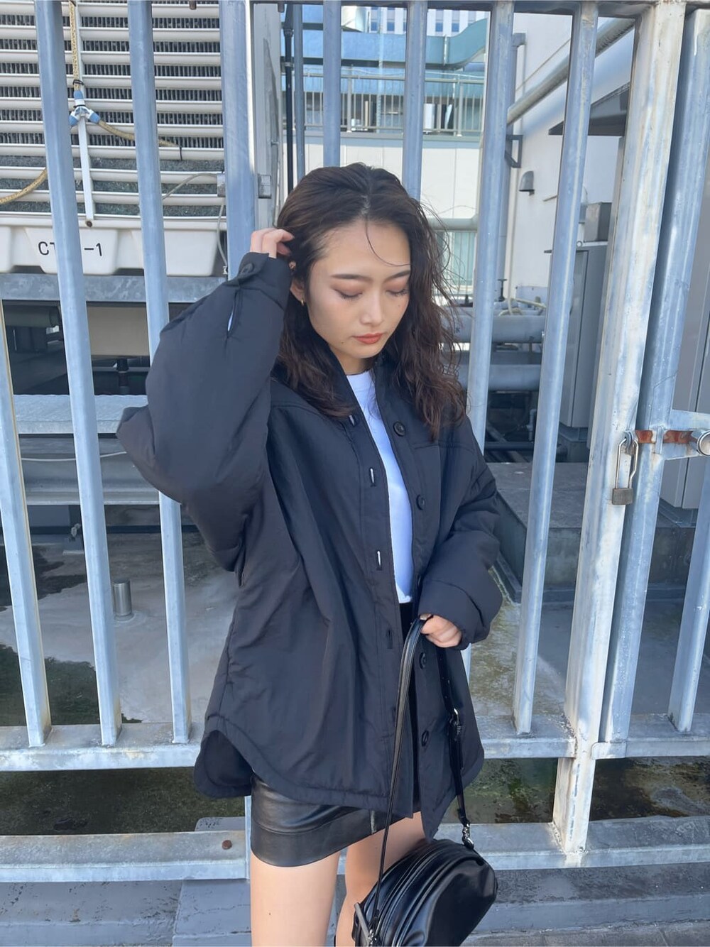 ブラック系のブルゾン、ブラック系のスカート、ホワイト系のTシャツ/カットソーを着用したレディースの秋コーディネートの4枚目の写真