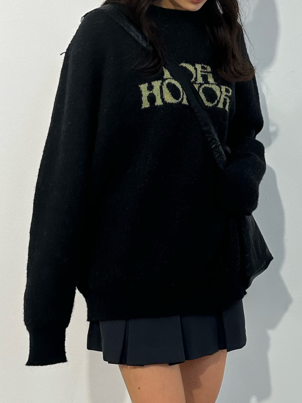 ブラック系のニット/セーター、グレー系のスカート、ブラック系のブーツを着用したレディースの冬コーディネートの4枚目の写真