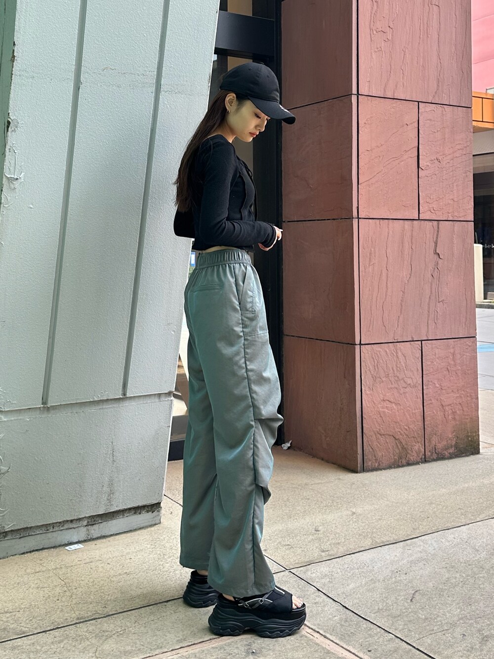 グリーン系のその他パンツ、ブラック系のTシャツ/カットソー、ブラック系のサンダルを着用したレディースの春コーディネートの2枚目の写真