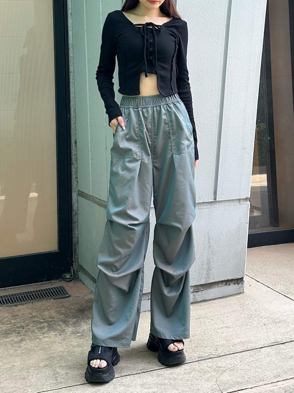 グリーン系のその他パンツ、ブラック系のTシャツ/カットソー、ブラック系のサンダルを着用したレディースの春コーディネートの4枚目の写真