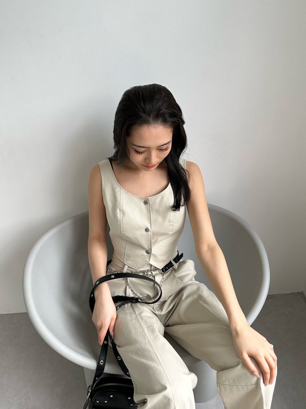 ホワイト系のその他パンツ、ホワイト系のキャミソール、ブラック系のショルダーバッグを着用したレディースの夏コーディネートの4枚目の写真