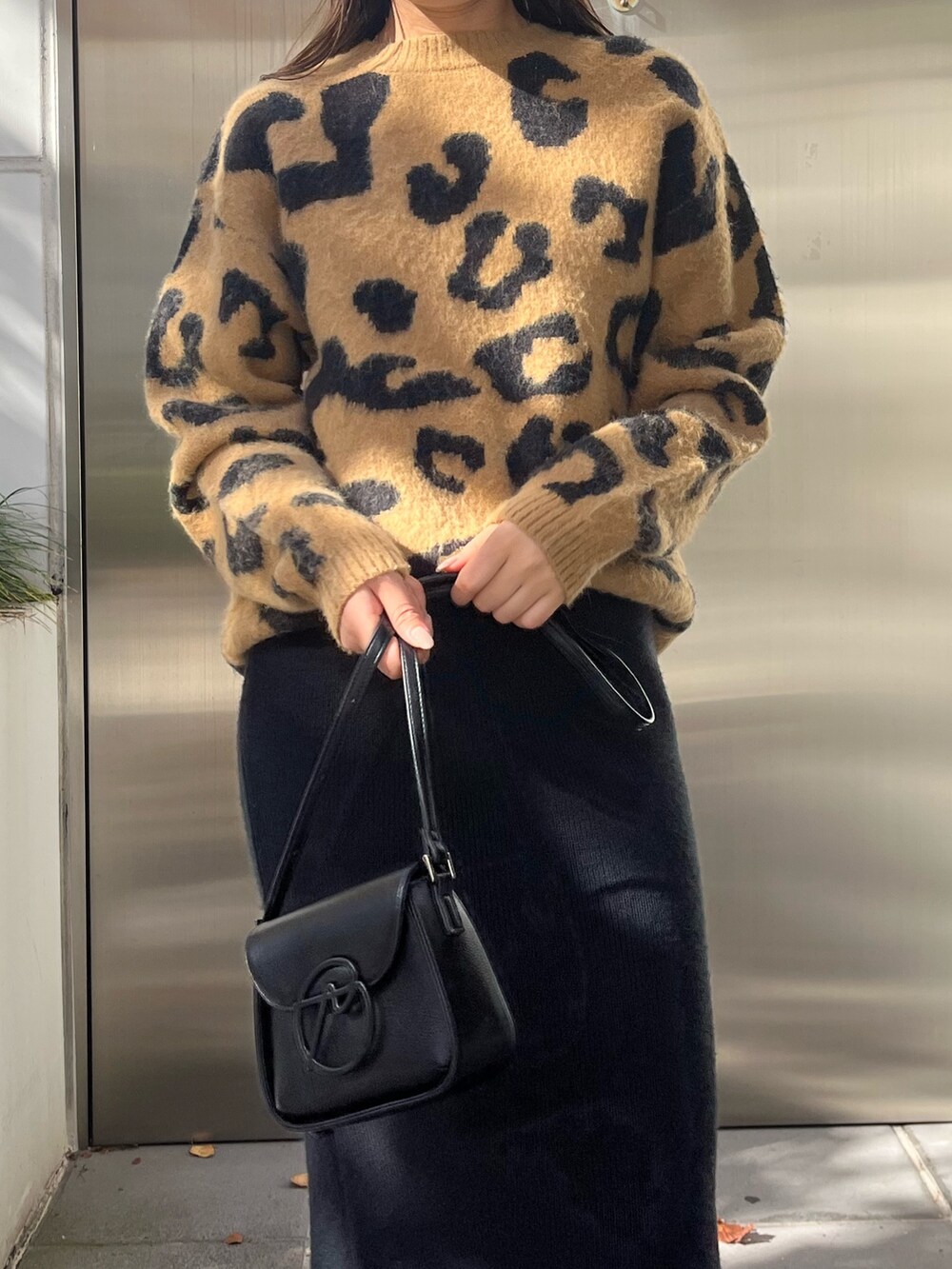 ベージュ系のニット/セーター、ブラウン系のブーツ、ブラック系のスカートを着用したレディースの秋コーディネートの4枚目の写真