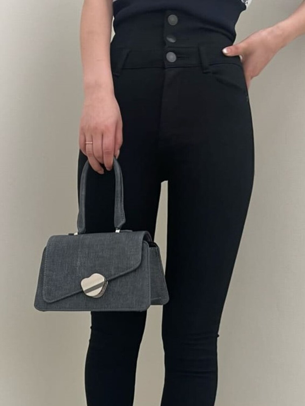 ホワイト系のローファー、ブラック系のハンドバッグ、ブラック系のデニムパンツを着用したレディースの春コーディネートの7枚目の写真