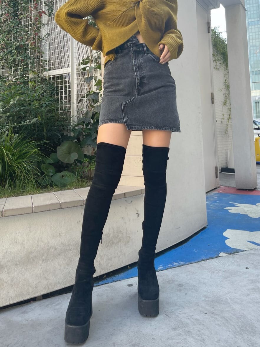 ブラック系のブーツ、ブラック系のハンドバッグ、イエロー系のニット/セーターを着用したレディースの秋コーディネートの5枚目の写真