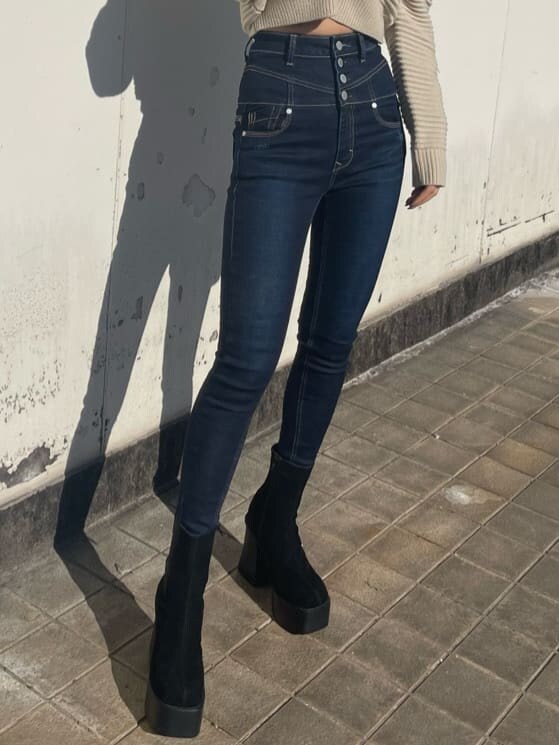 ホワイト系のニット/セーター、ブルー系のデニムパンツ、ブラック系のブーツを着用したレディースの冬コーディネートの4枚目の写真