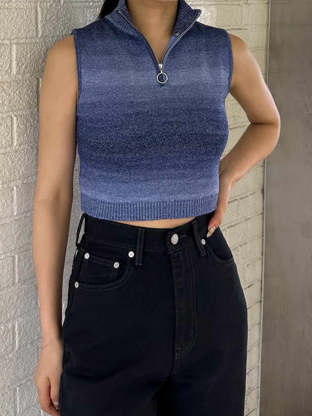 ブラック系のデニムパンツ、ブルー系のタンクトップ、ホワイト系のサンダルを着用したレディースの春コーディネートの5枚目の写真