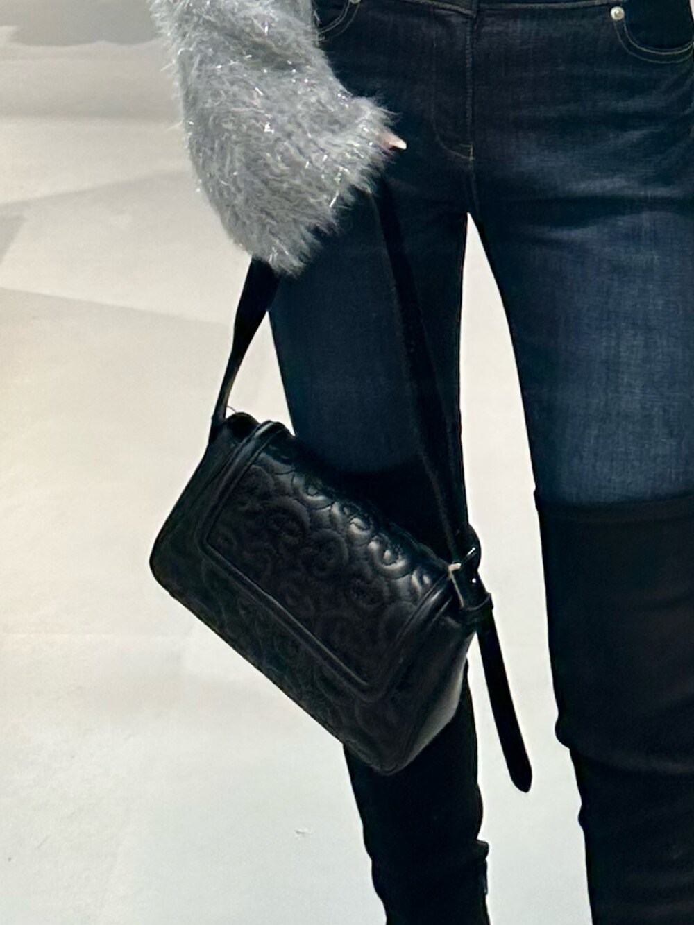 グレー系のニット/セーター、ブルー系のデニムパンツ、ブラック系のハンドバッグを着用したレディースの秋コーディネートの5枚目の写真