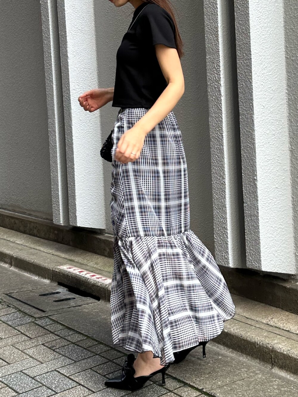 ブラック系のTシャツ/カットソー、ブラック系のパンプス、ブラック系のスカートを着用したレディースの秋コーディネートの3枚目の写真