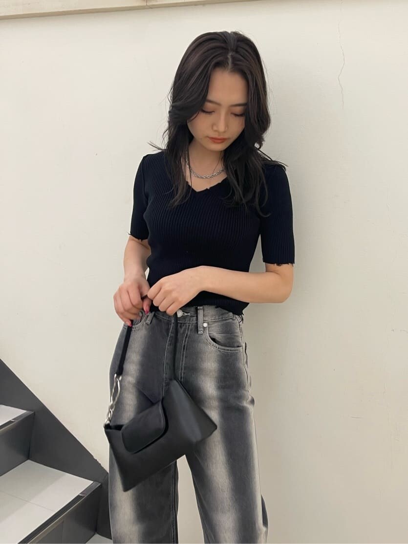 ブラック系のサンダル、ブラック系のハンドバッグ、ブラック系のデニムパンツを着用したレディースの春コーディネートの3枚目の写真