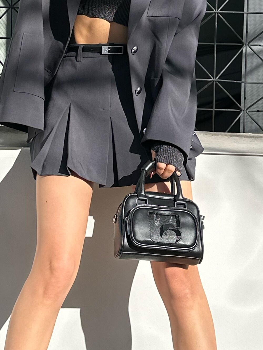 グレー系のスカート、ブラック系のスニーカー、その他のニット/セーターを着用したレディースの冬コーディネートの7枚目の写真