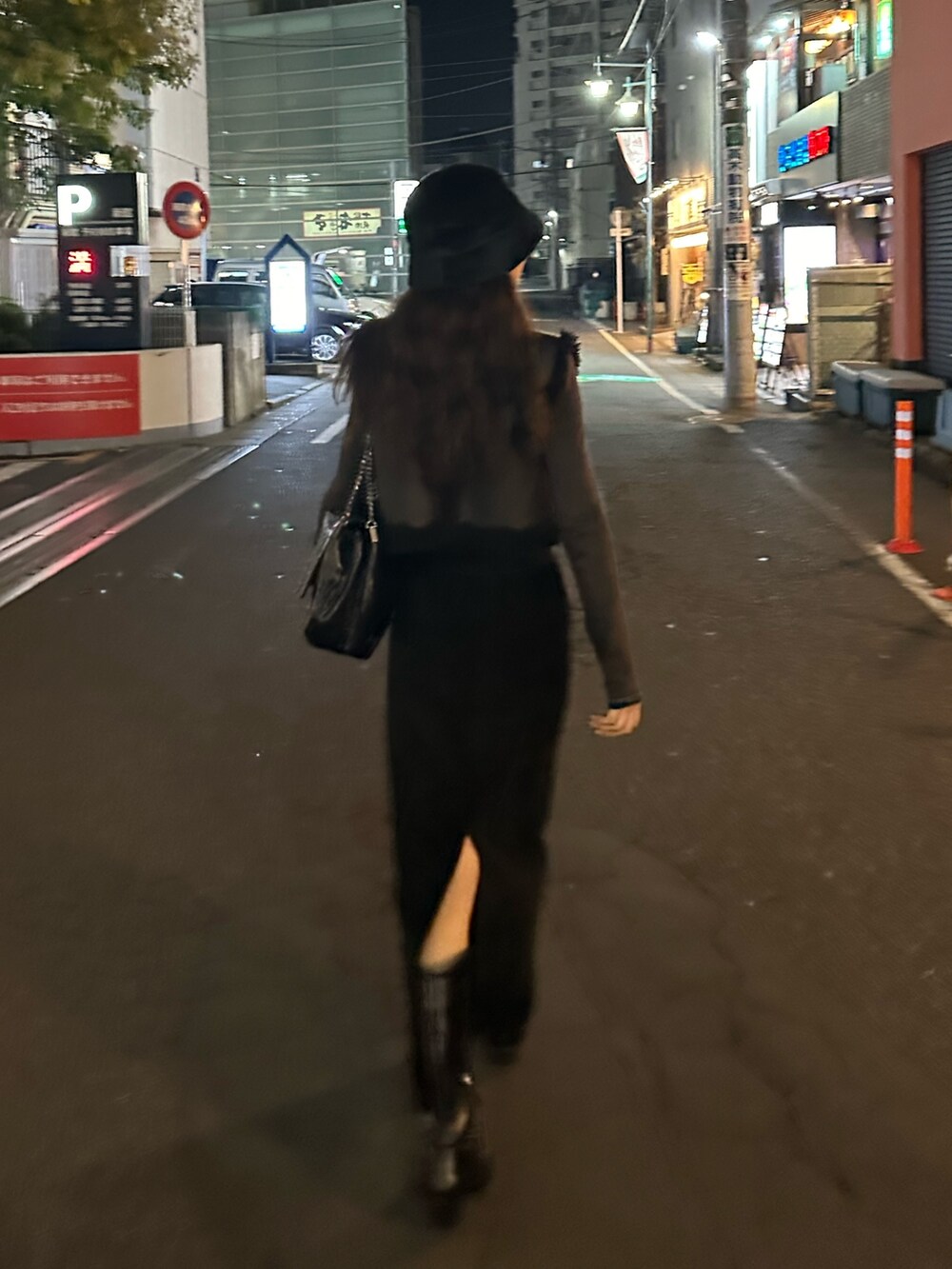 ブラック系のスカート、ブラック系のブーツ、ブラック系のハットを着用したレディースの冬コーディネートの4枚目の写真