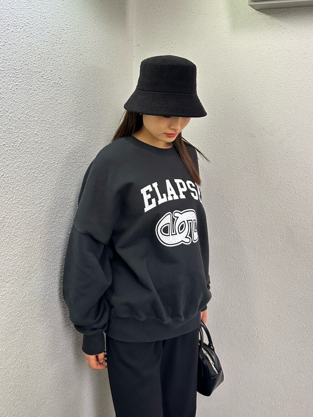 ブラック系のその他パンツ、ブラック系のハンドバッグ、ブラック系のTシャツ/カットソーを着用したレディースの冬コーディネートの7枚目の写真