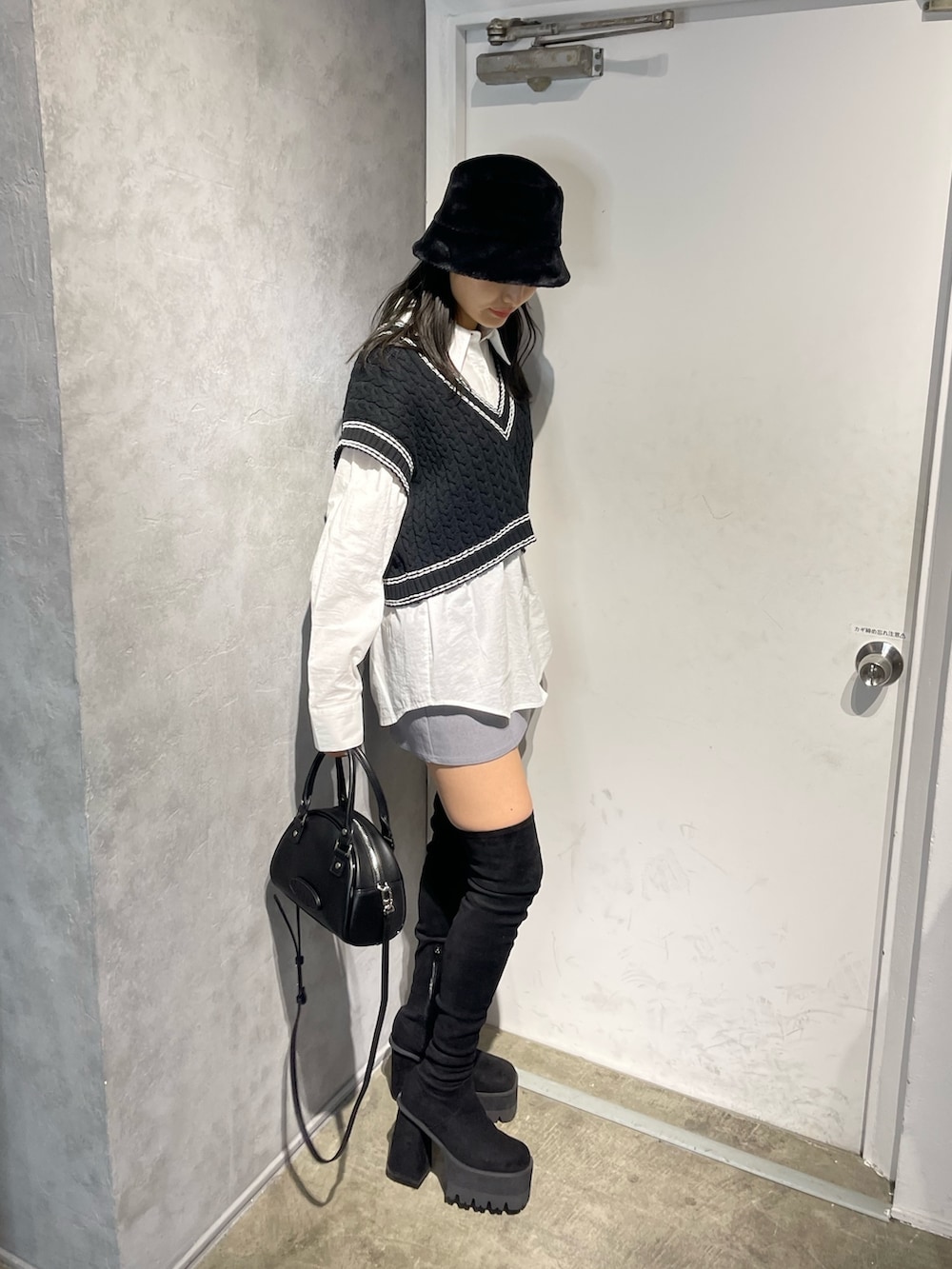 ブラック系のブーツ、ブラック系のベスト、ホワイト系のシャツ/ブラウスを着用したレディースの冬コーディネートの3枚目の写真