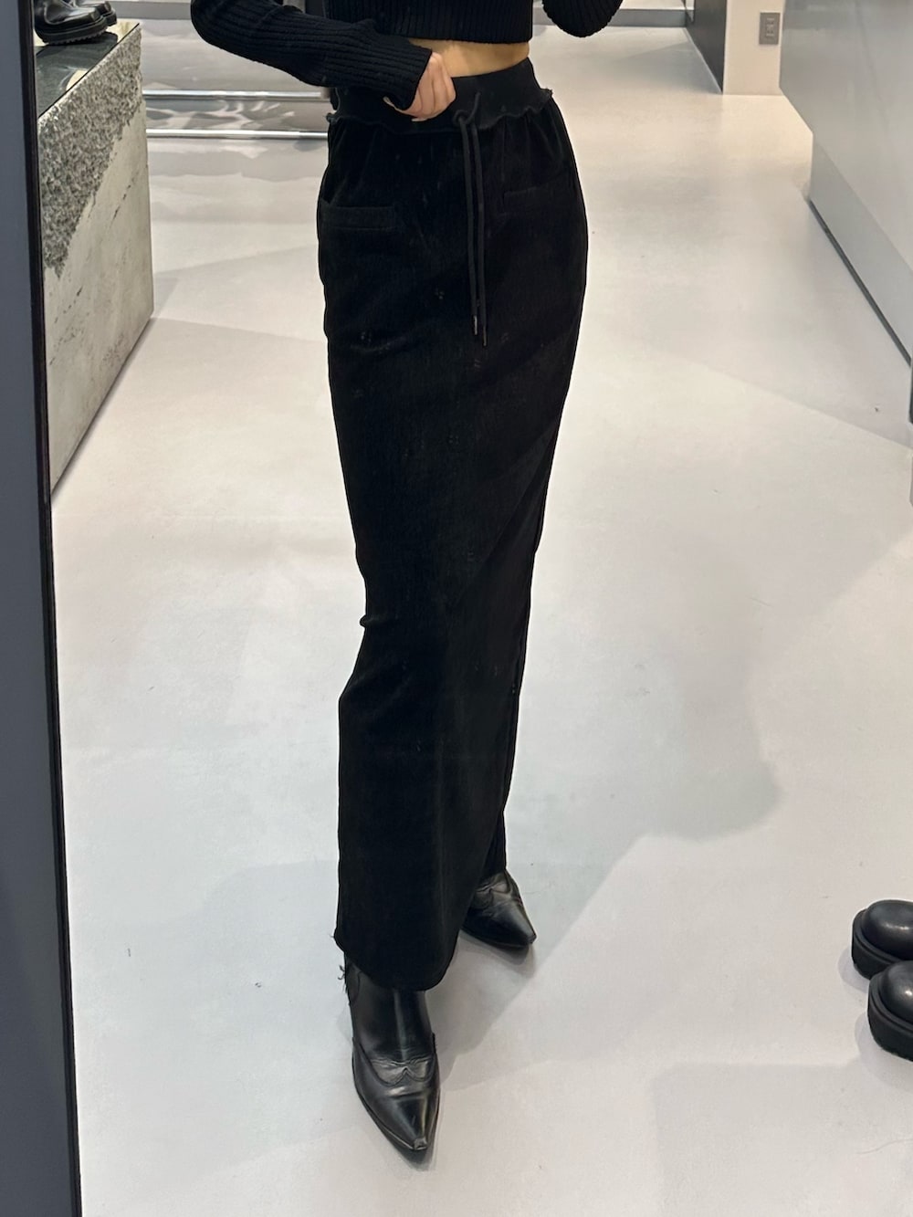 ブラック系のブルゾン、ブラック系のニット/セーター、ブラック系のブーツを着用したレディースの冬コーディネートの6枚目の写真