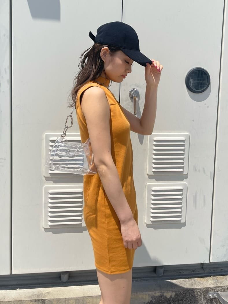 ブラック系のサンダル、オレンジ系のワンピース、その他のハンドバッグを着用したレディースの春コーディネートの5枚目の写真