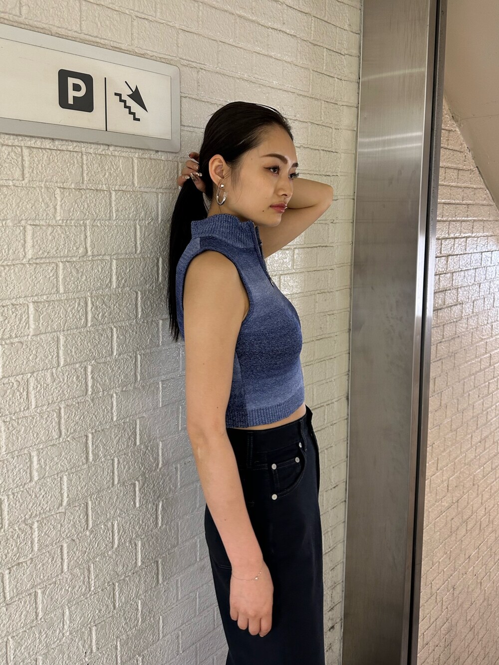 ブラック系のデニムパンツ、ブルー系のタンクトップ、ホワイト系のサンダルを着用したレディースの春コーディネートの4枚目の写真