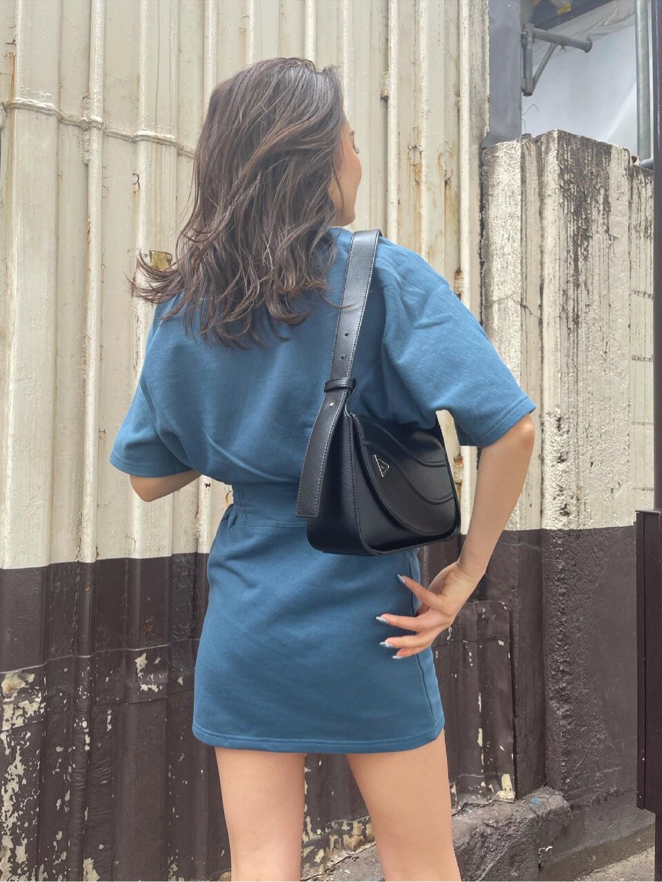 ブラック系のサンダル、ブラック系のショルダーバッグ、ブルー系のワンピースを着用したレディースの夏コーディネートの2枚目の写真