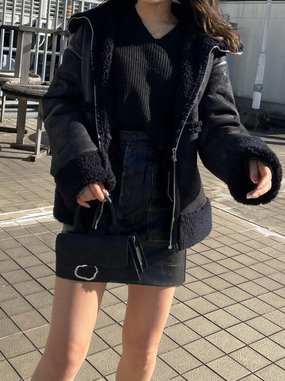 その他のブーツ、ブラック系のニット/セーター、ブラック系のスカートを着用したレディースの冬コーディネートの2枚目の写真