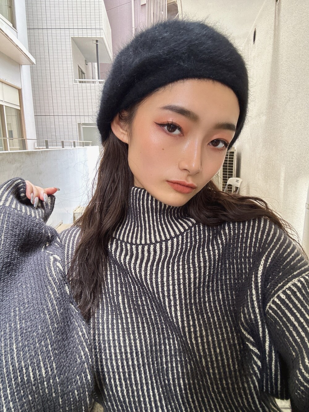 ブラック系のスカート、ブラック系のニット/セーター、ブラック系のハンドバッグを着用したレディースの秋コーディネートの8枚目の写真