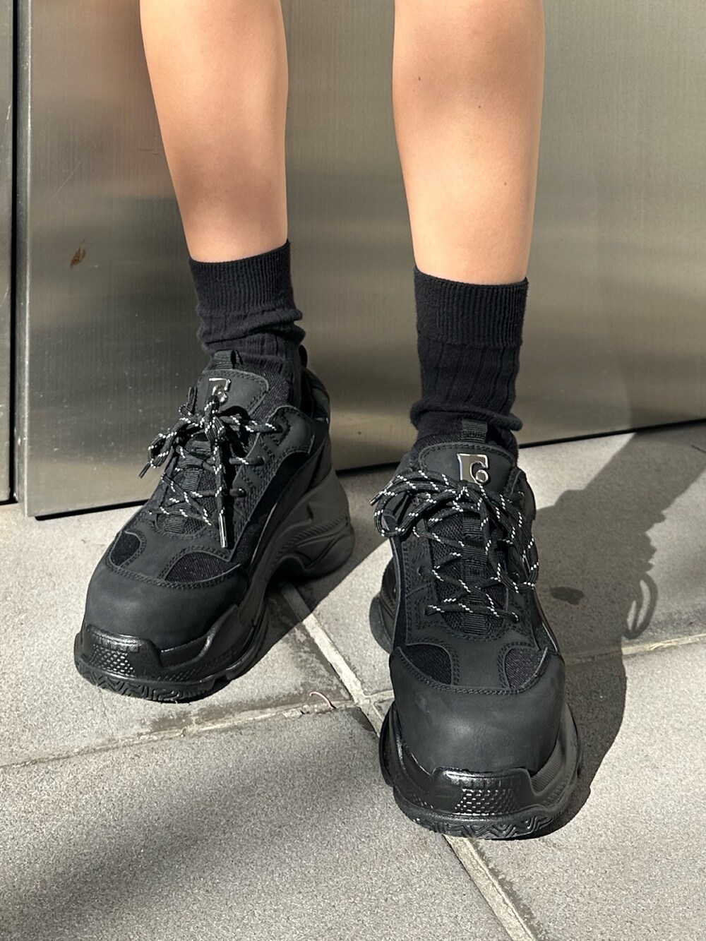 グレー系のスカート、ブラック系のスニーカー、その他のニット/セーターを着用したレディースの冬コーディネートの6枚目の写真