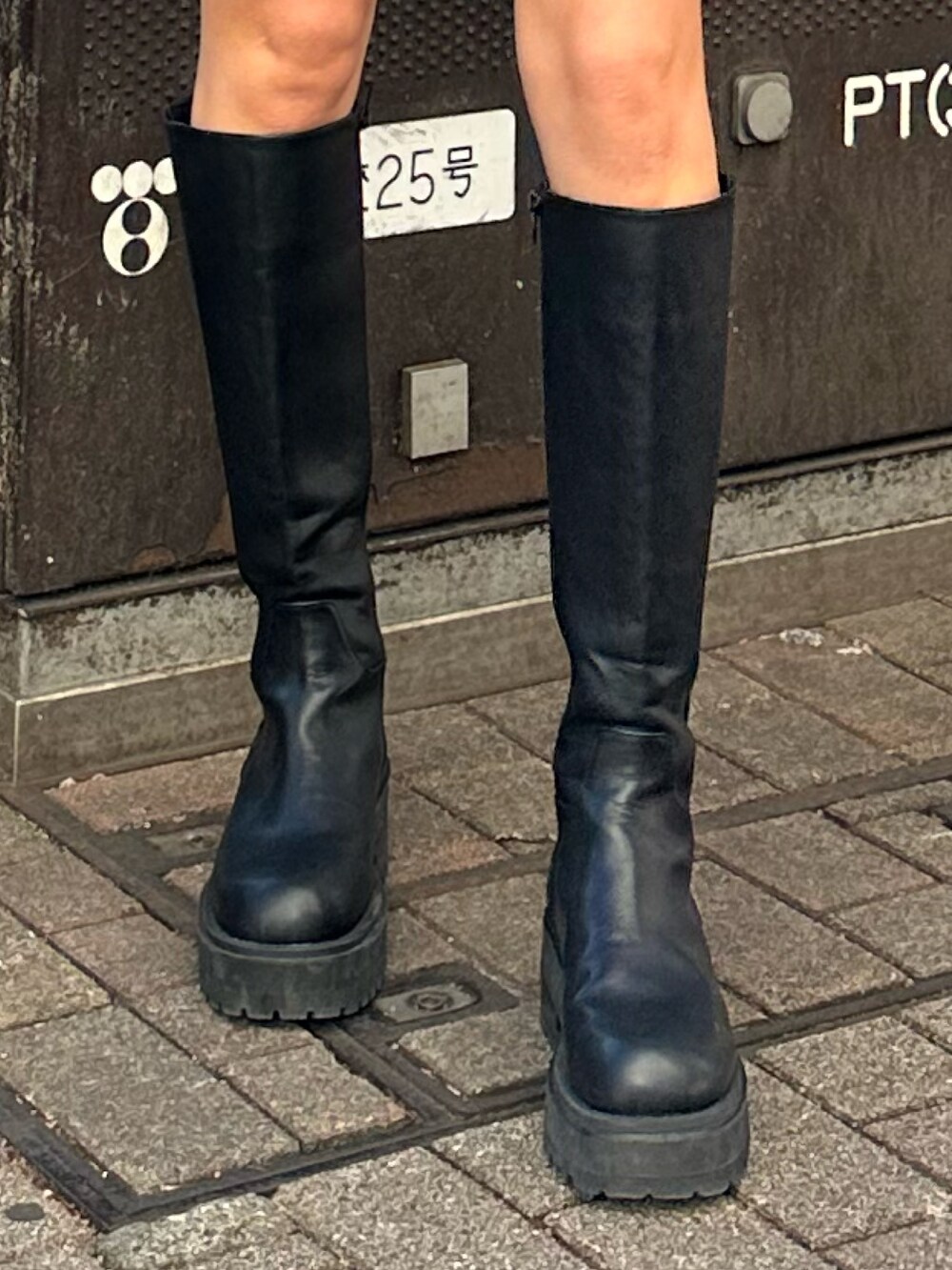 ベージュ系のスカート、ブラック系のブーツ、ホワイト系のニット/セーターを着用したレディースの冬コーディネートの5枚目の写真