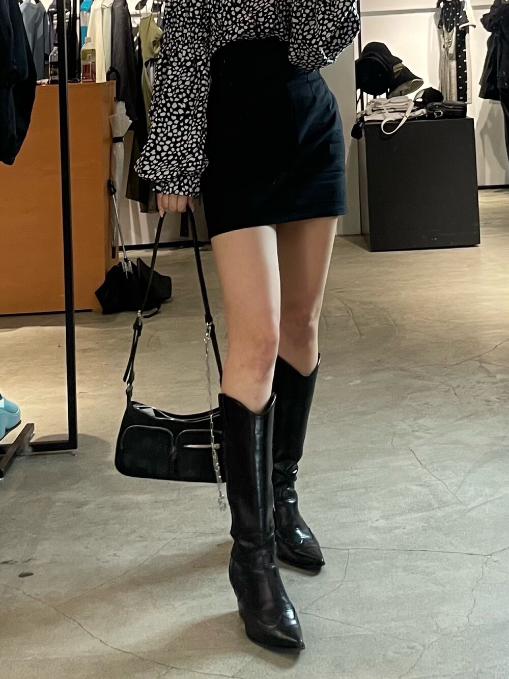 ブラック系のスカート、ブラック系のブーツ、その他のシャツ/ブラウスを着用したレディースの春コーディネートの7枚目の写真