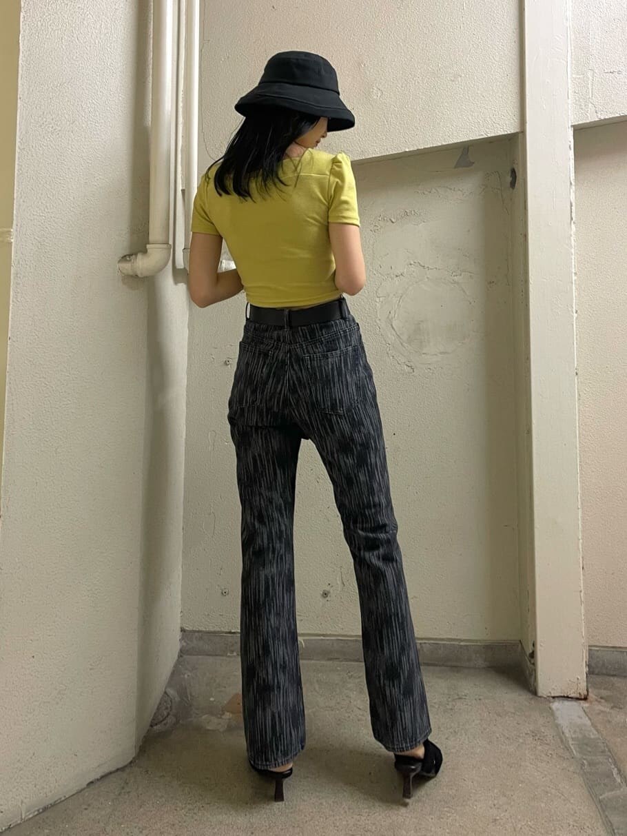 ブラック系のデニムパンツ、イエロー系のTシャツ/カットソー、ブラック系のサンダルを着用したレディースの夏コーディネートの3枚目の写真