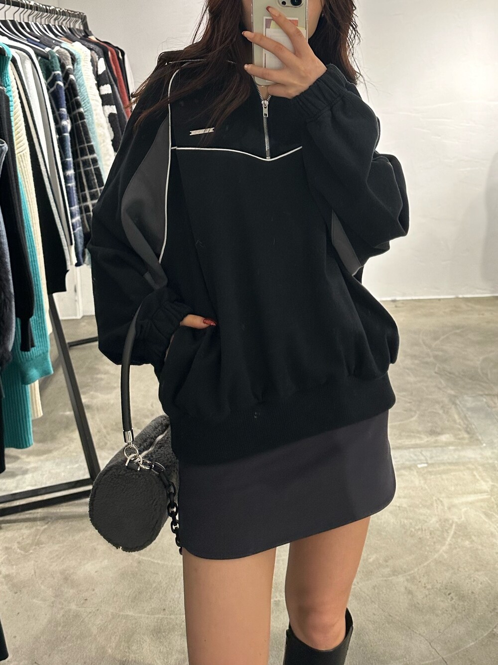 グレー系のスカート、グレー系のハンドバッグ、ブラック系のブーツを着用したレディースの冬コーディネートの4枚目の写真