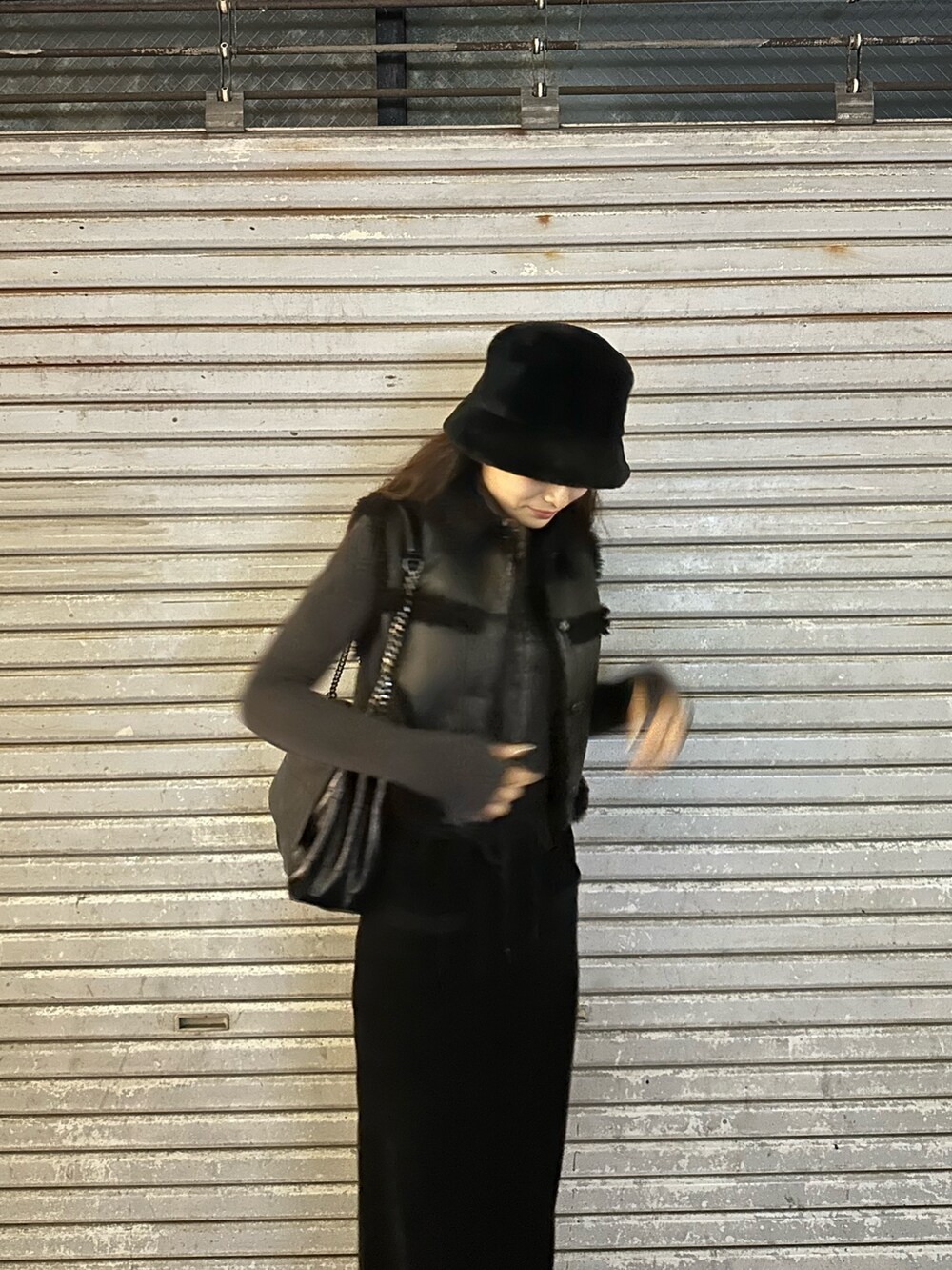 ブラック系のスカート、ブラック系のブーツ、ブラック系のハットを着用したレディースの冬コーディネートの5枚目の写真