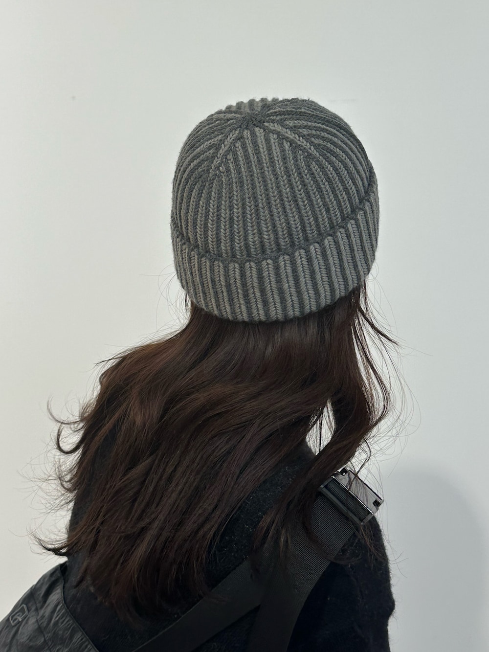 ブラック系のニット/セーター、グレー系のスカート、ブラック系のブーツを着用したレディースの冬コーディネートの6枚目の写真