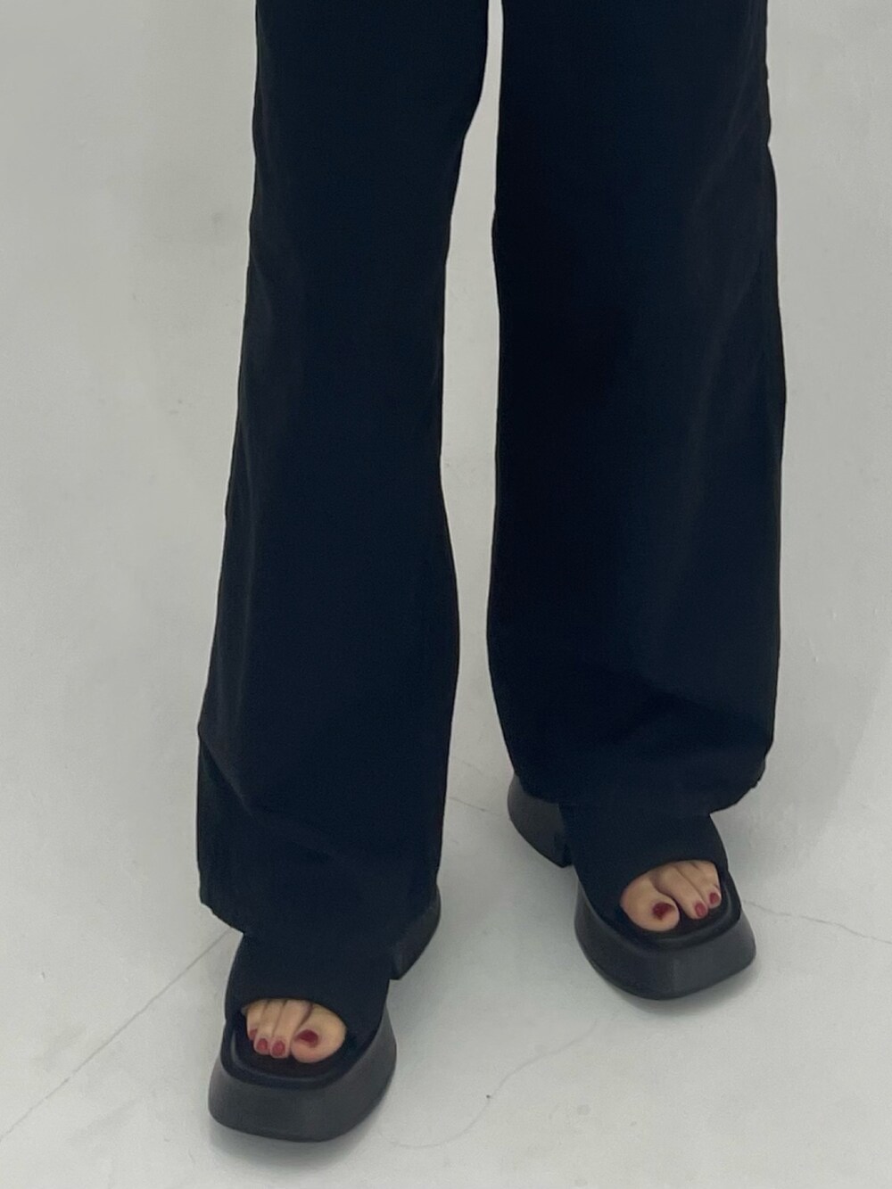 ブラック系のサロペット/オーバーオール、ホワイト系のハンドバッグ、ブラック系のサンダルを着用したレディースの春コーディネートの7枚目の写真