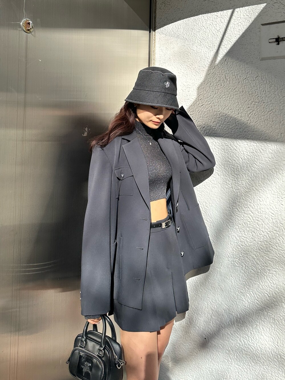 グレー系のスカート、ブラック系のスニーカー、その他のニット/セーターを着用したレディースの冬コーディネートの4枚目の写真