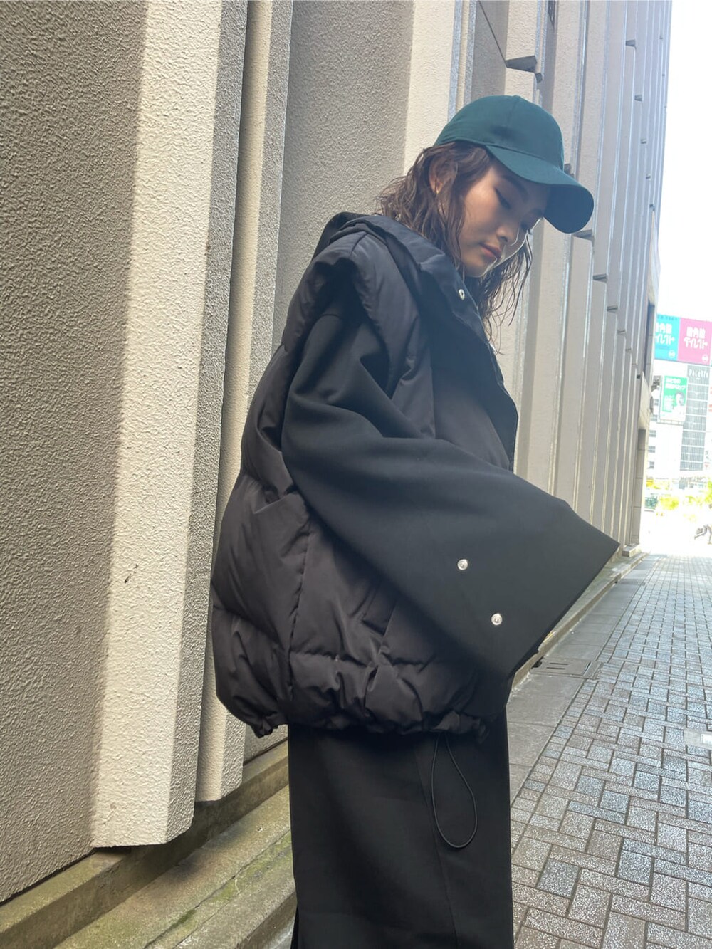 ブラック系のダウンベスト、ブラック系のワンピース、ブラック系のブーツを着用したレディースの秋コーディネートの8枚目の写真