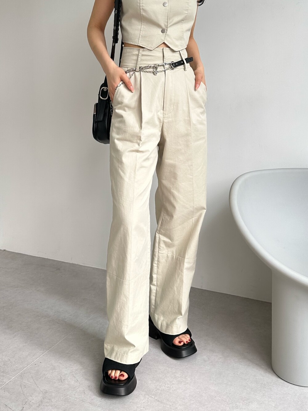 ホワイト系のその他パンツ、ホワイト系のキャミソール、ブラック系のショルダーバッグを着用したレディースの夏コーディネートの10枚目の写真