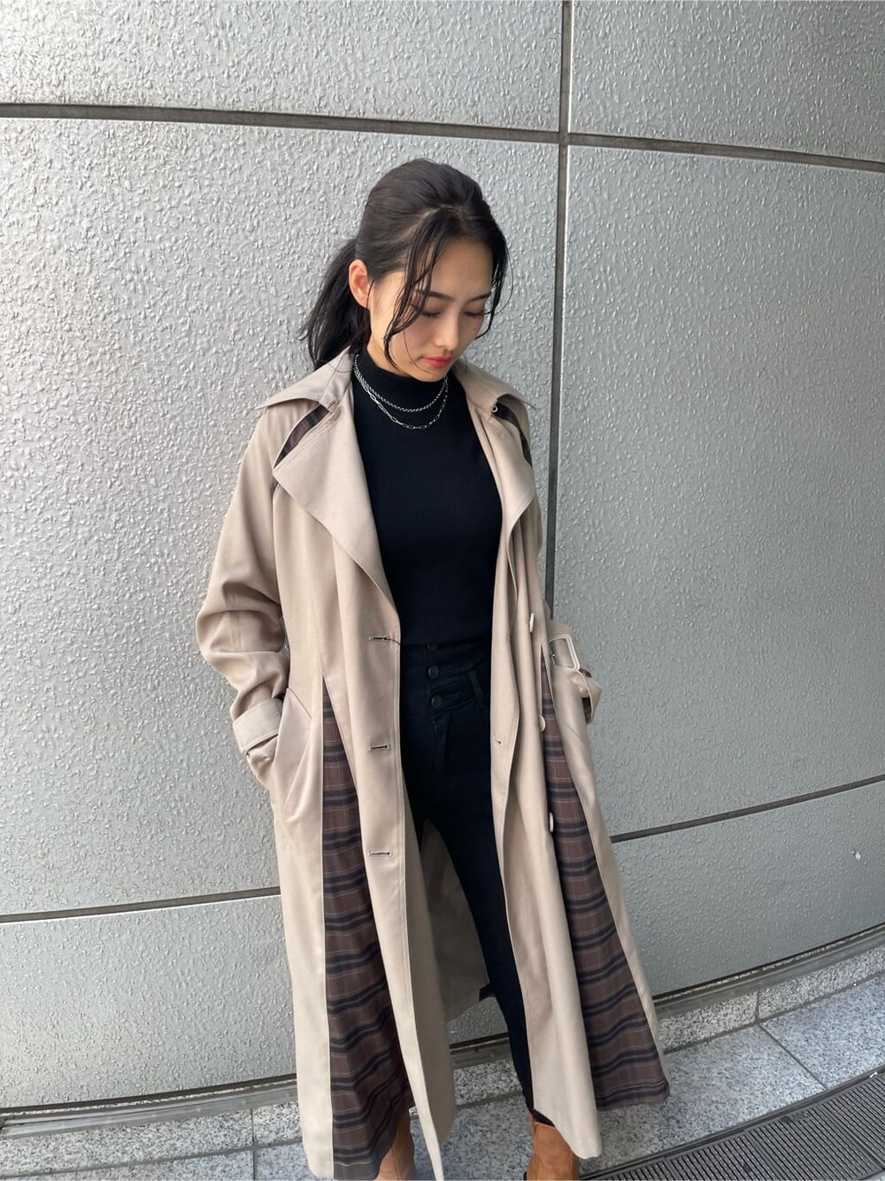ベージュ系のトレンチコート、ブラック系のTシャツ/カットソー、ブラック系のデニムパンツを着用したレディースの夏コーディネートの5枚目の写真