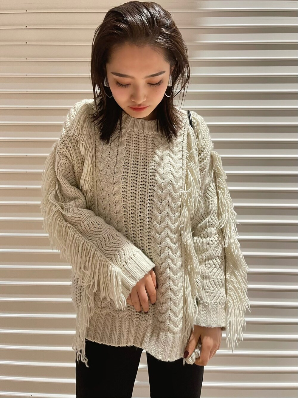 ブラック系のショルダーバッグ、ブラック系のブーツ、グレー系のデニムパンツを着用したレディースの冬コーディネートの3枚目の写真