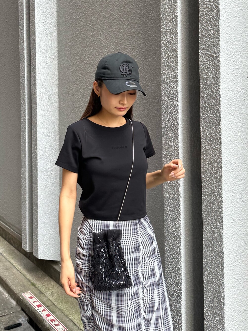 ブラック系のTシャツ/カットソー、ブラック系のパンプス、ブラック系のスカートを着用したレディースの秋コーディネートの4枚目の写真