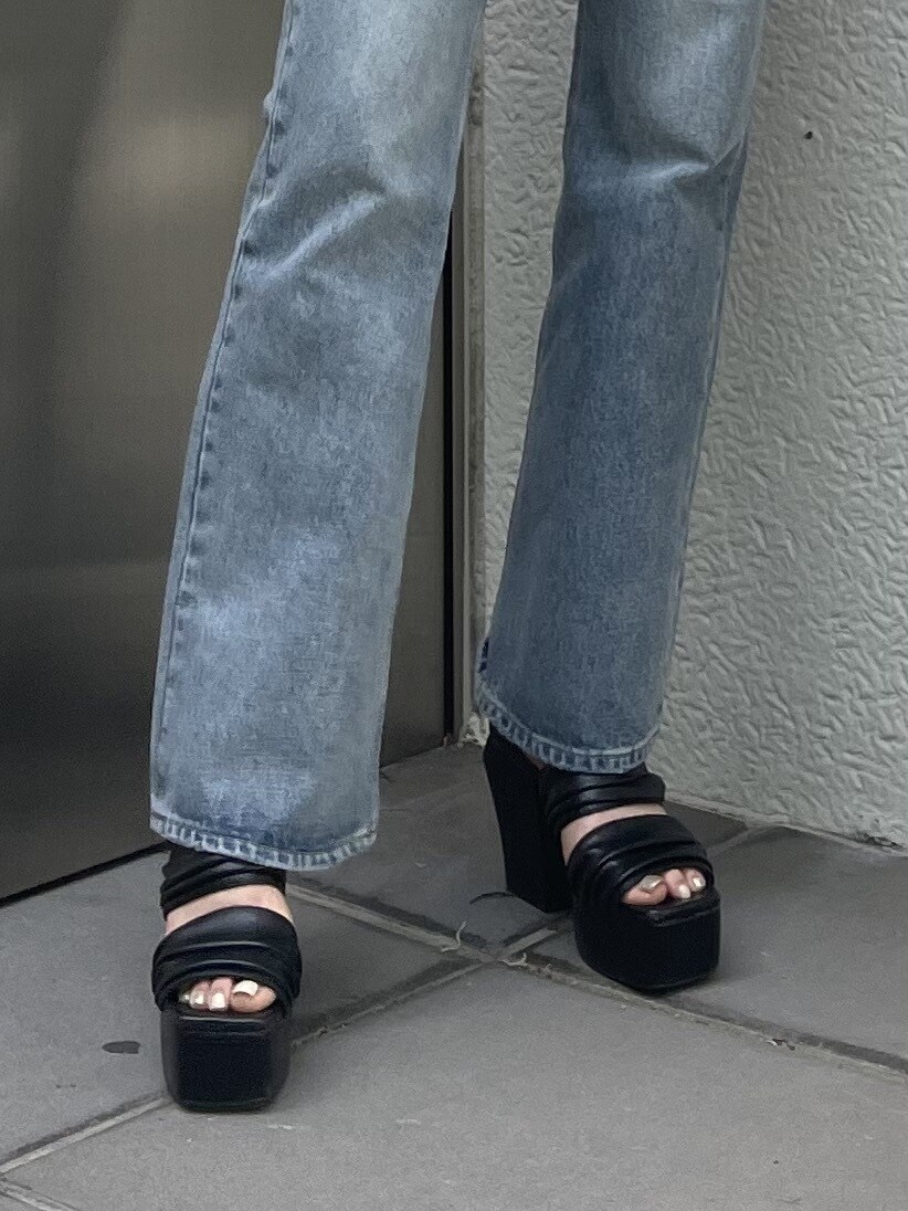 ホワイト系のショルダーバッグ、ブラック系のサンダル、ブルー系のデニムパンツを着用したレディースの春コーディネートの4枚目の写真