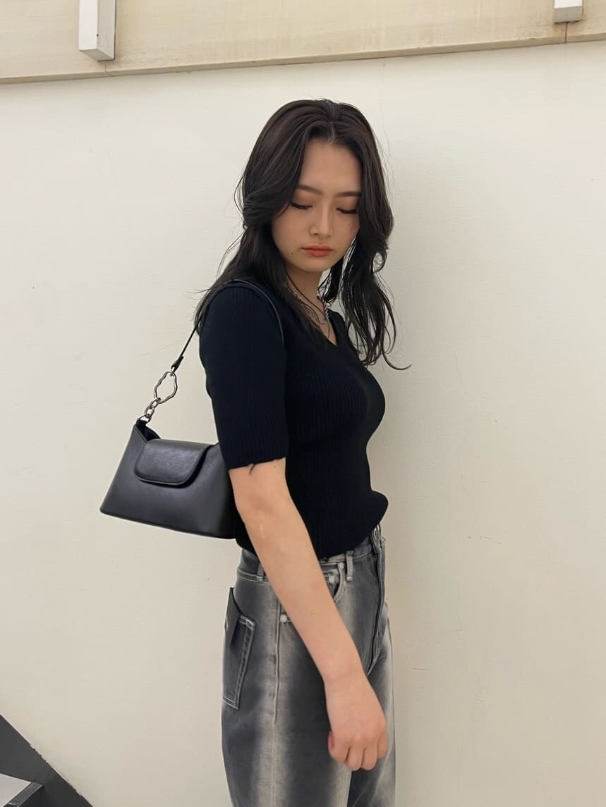 ブラック系のサンダル、ブラック系のハンドバッグ、ブラック系のデニムパンツを着用したレディースの春コーディネートの4枚目の写真