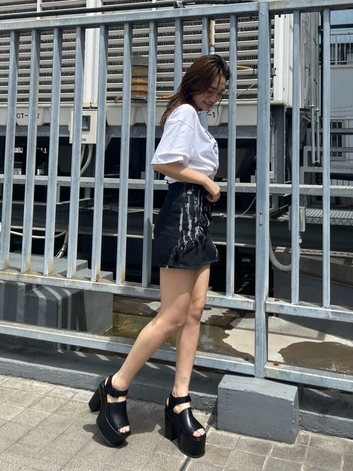 ブラック系のサンダル、ブラック系のデニムパンツ、ホワイト系のTシャツ/カットソーを着用したレディースの春コーディネートの2枚目の写真