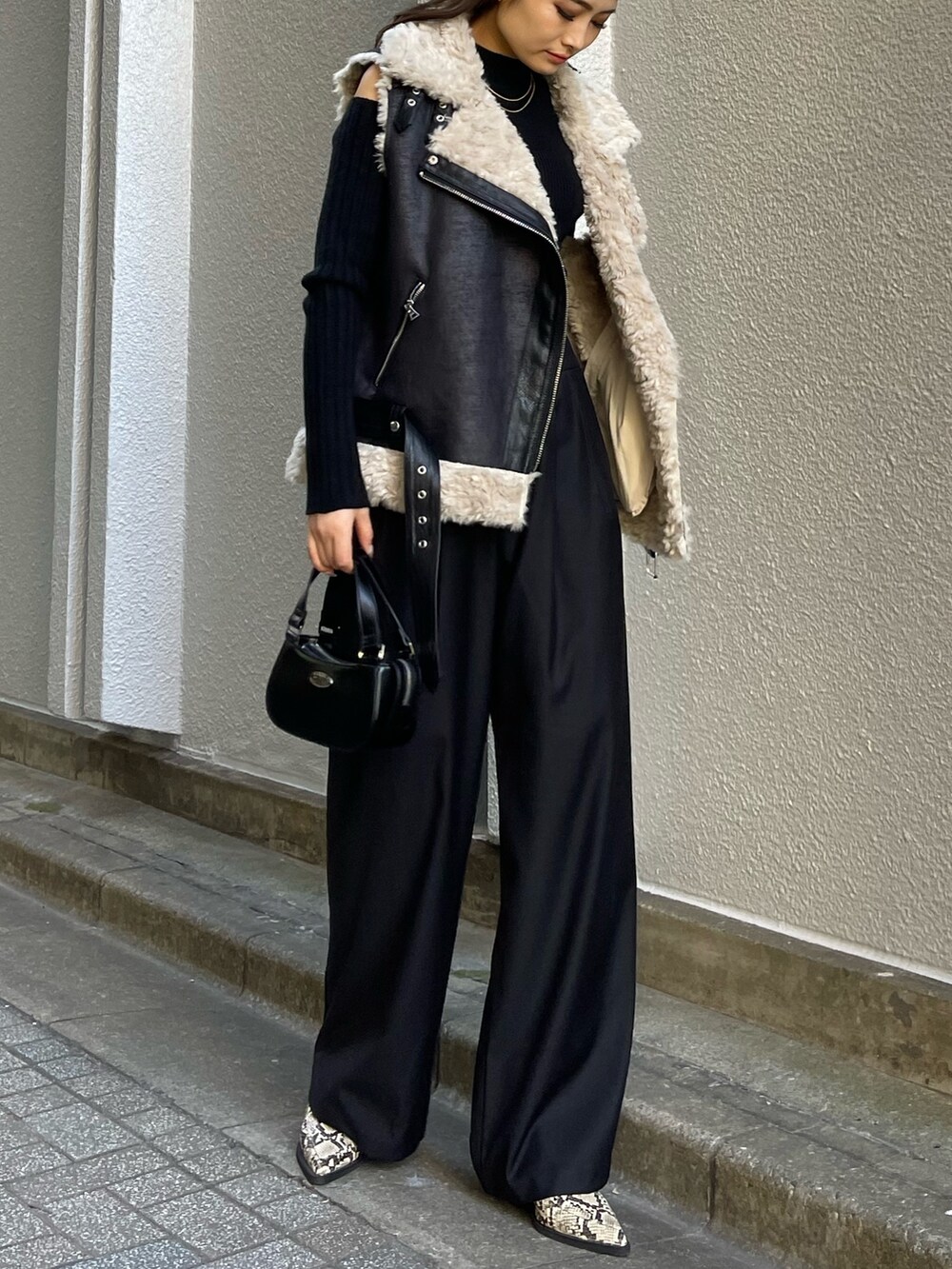 ブラック系のニット/セーター、ブラック系のその他パンツ、ブラック系のハンドバッグを着用したレディースの冬コーディネートの3枚目の写真