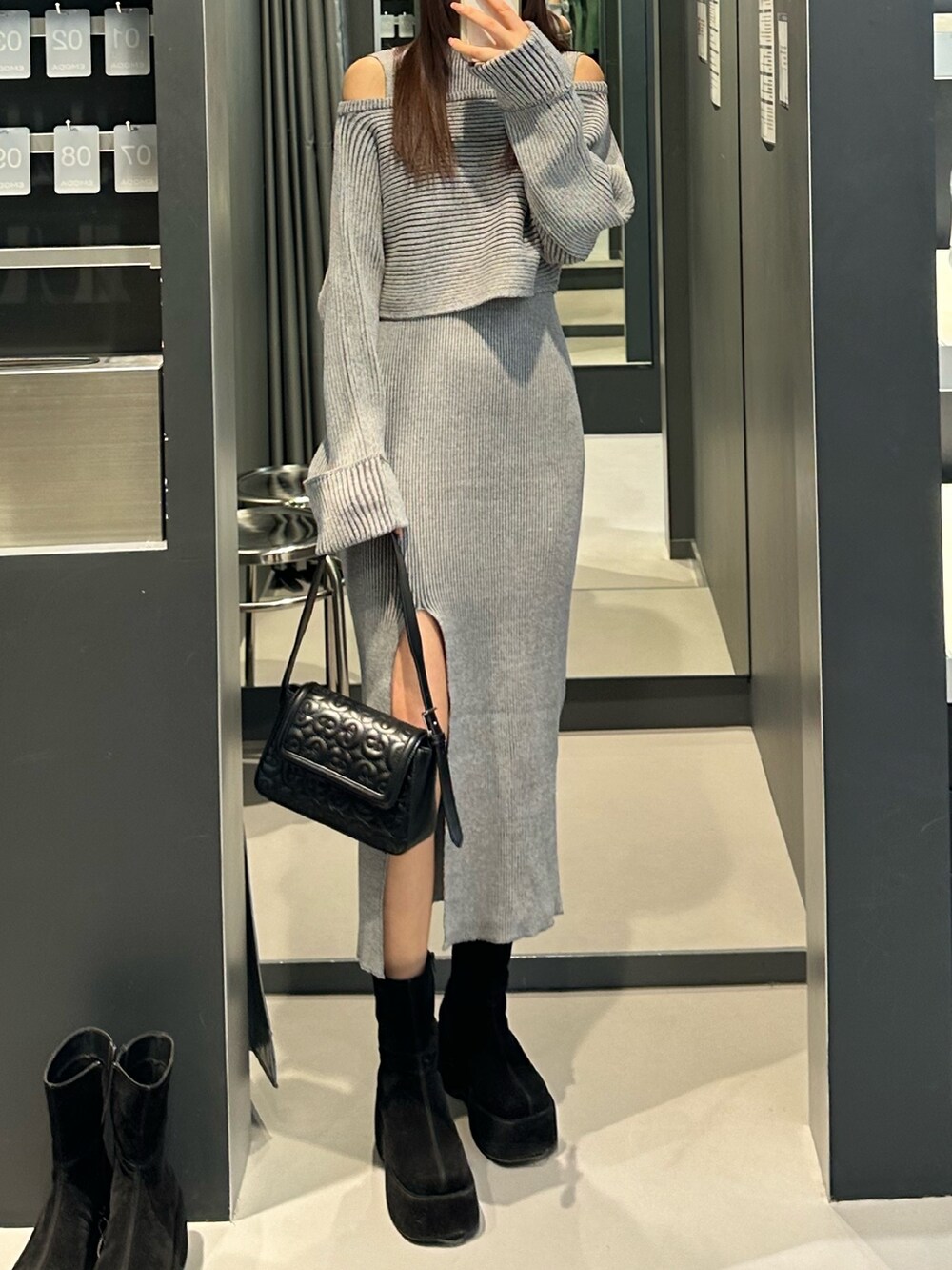 グレー系のワンピース、ブラック系のブーツ、ブラック系のハンドバッグを着用したレディースの冬コーディネートの4枚目の写真