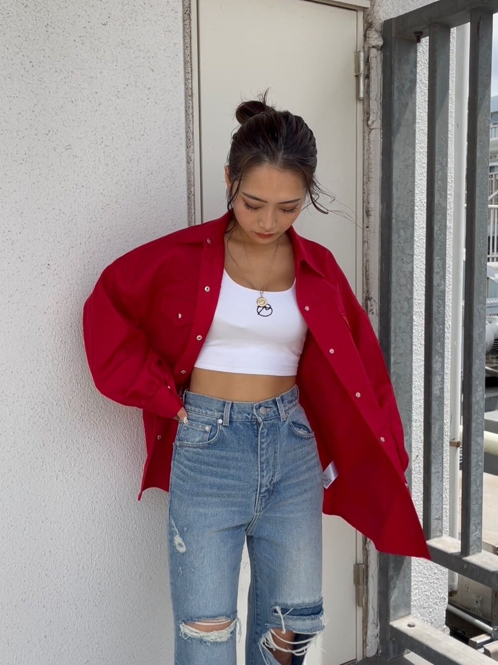 ブルー系のデニムパンツ、ベージュ系のスリッポン、レッド系のシャツ/ブラウスを着用したレディースの秋コーディネートの4枚目の写真