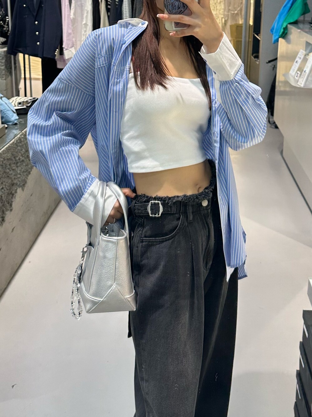 ブラック系のデニムパンツ、ホワイト系のキャミソール、ブルー系のシャツ/ブラウスを着用したレディースの冬コーディネートの4枚目の写真