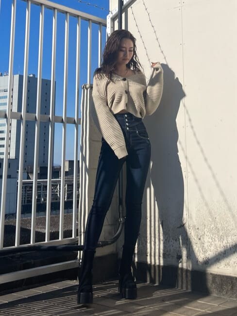 ホワイト系のニット/セーター、ブルー系のデニムパンツ、ブラック系のブーツを着用したレディースの冬コーディネートの2枚目の写真