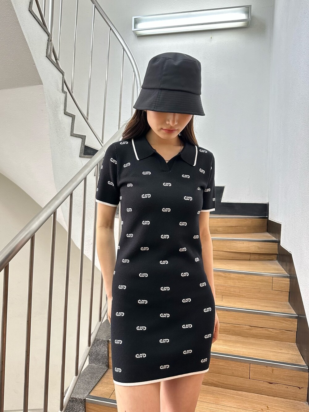 ブラック系のワンピース、ブラック系のサンダル、ブラック系のハットを着用したレディースの春コーディネートの4枚目の写真