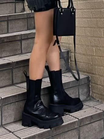 ブラック系のブーツ、ブラック系のスカート、ブラック系のシャツ/ブラウスを着用したレディースの秋コーディネートの7枚目の写真