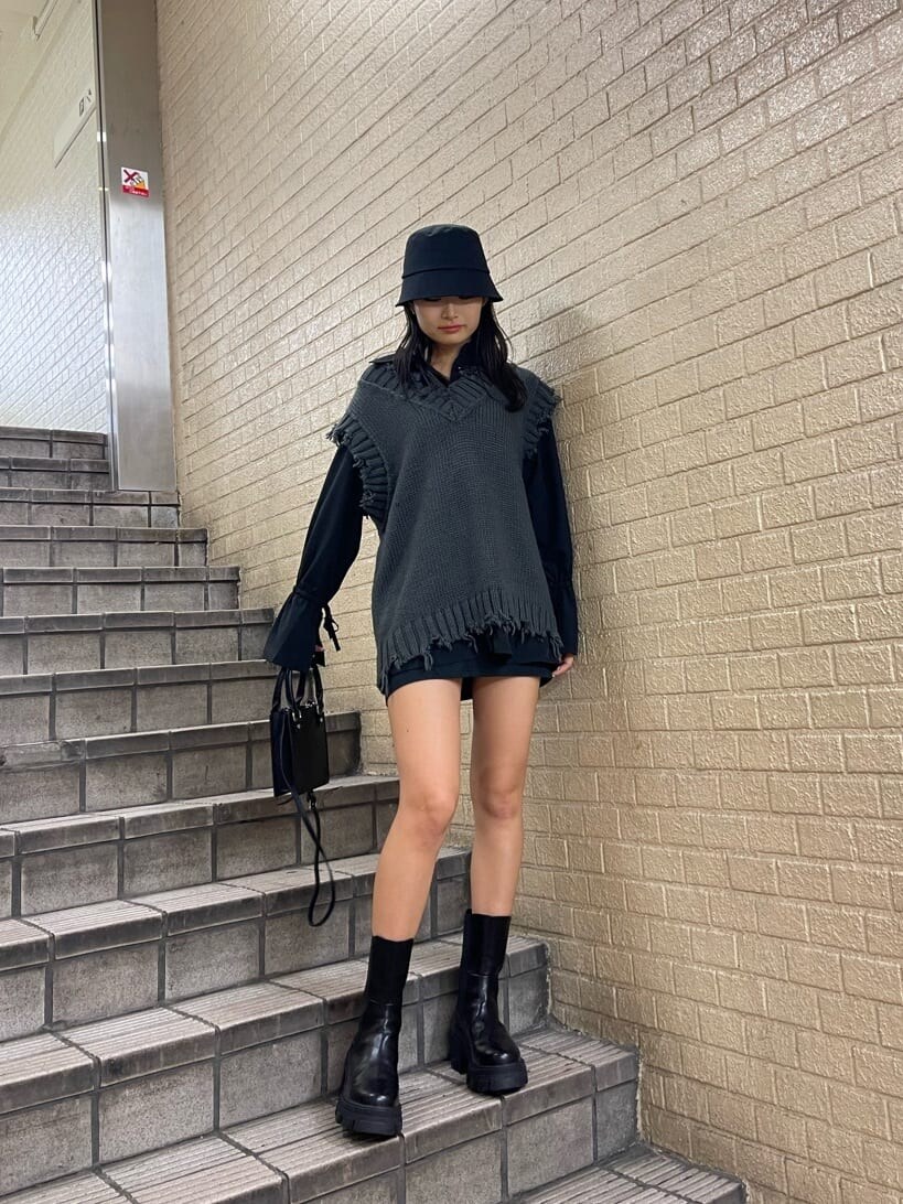 ブラック系のブーツ、ブラック系のスカート、ブラック系のシャツ/ブラウスを着用したレディースの秋コーディネートの2枚目の写真